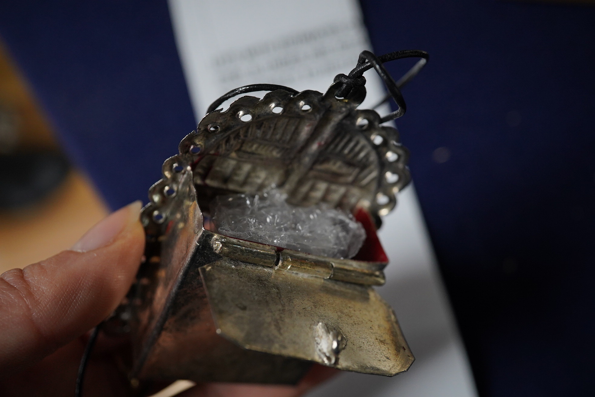 A Grayson Perry reliquary white metal pendant containing a section of tile, with Tate box, 7.5cm high. Condition - good